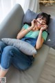 A woman sitting on a couch talking on a cell phone.