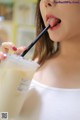 A woman sticking out her tongue while holding a straw.