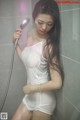 A woman in a white dress is taking a shower.