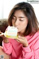 A woman sitting on a couch eating a piece of cake.