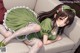 A girl in a green dress laying on a couch.