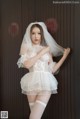 A woman in a wedding dress and stockings posing for a picture.