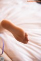 A close up of a person's foot on a bed.