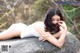 A woman laying on top of a large rock.