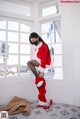 A woman in a santa suit is posing for a picture.