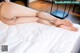 A woman laying on top of a bed with her legs crossed.