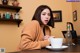 A woman sitting at a table with a cup of coffee.