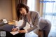 A woman in a business suit writing on a piece of paper.