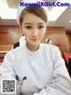 a woman in a white uniform sitting at a desk