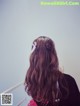 A woman with long brown hair with a flower in her hair.