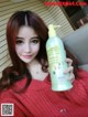 A woman holding a bottle of shampoo in her hand.