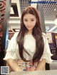 A woman with long brown hair standing in front of a counter.