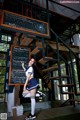 A woman in a school uniform standing in front of a blackboard.