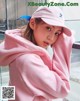 a woman wearing a pink hoodie and a pink hat