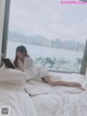 A woman laying on a bed reading a book.