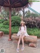 A woman sitting on a wooden bench in a park.