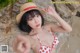 A woman in a red and white bikini and a straw hat.