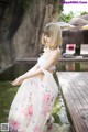 A woman in a white dress standing in a pool.