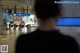 A man standing in an airport looking at a sign.