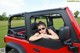 A woman is sitting in the back of a red jeep.