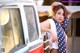 A woman leaning against the side of a red and white van.