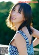 A woman in a blue and white dress posing for a picture.